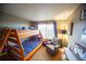Shared bedroom with bunk beds, large windows and an armchair at 9950 Sydney Ln, Highlands Ranch, CO 80130