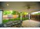 Relax on this covered patio with ceiling fan, stone flooring and views of the backyard at 9950 Sydney Ln, Highlands Ranch, CO 80130