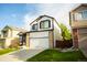 Two-story home with a two-car garage, brick accents, a well-manicured lawn and blue sky at 9950 Sydney Ln, Highlands Ranch, CO 80130