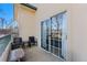 The covered patio features neutral walls, patio furniture, and sliding glass doors at 8671 E Dry Creek Rd # 721, Englewood, CO 80112