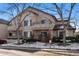 A condo building with snow-covered ground, bare trees, and a parking area at 8671 E Dry Creek Rd # 721, Englewood, CO 80112