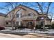 Charming exterior featuring brick accents, balconies, and mature trees in a landscaped setting at 8671 E Dry Creek Rd # 721, Englewood, CO 80112