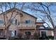 Charming multi-story home featuring a balcony, brick accents, and tan stucco exterior at 8671 E Dry Creek Rd # 721, Englewood, CO 80112