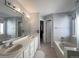 Bathroom featuring double sinks, vanity lighting, and a separate soaking tub at 17037 E Wiley Pl, Parker, CO 80134