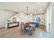 Bright dining area with wood floors, modern lighting, and an open concept connecting to the kitchen at 8586 Holman Ct # A, Arvada, CO 80005
