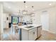 Bright living area showcasing wood floors, modern lighting, and an open concept connecting to the kitchen at 8586 Holman Ct # A, Arvada, CO 80005