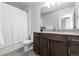 Modern bathroom with a wood vanity, granite countertop, and shower-tub combination at 8775 El Diente St, Arvada, CO 80007