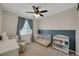 Charming Bedroom featuring a white crib, changing table, comfortable armchair, and a ceiling fan at 1148 Sunlit Dr, Castle Rock, CO 80109