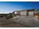 View of the home's three-car garage and wide driveway, complemented by landscaped front yard at 1148 Sunlit Dr, Castle Rock, CO 80109