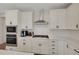 The kitchen features white cabinets, stainless steel appliances, and designer tile backsplash at 1148 Sunlit Dr, Castle Rock, CO 80109