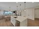 Open concept kitchen with island seating and stainless appliances flowing into living and dining areas at 1148 Sunlit Dr, Castle Rock, CO 80109