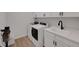 Well-lit laundry room with modern washer, dryer, sink, and ample storage at 1148 Sunlit Dr, Castle Rock, CO 80109