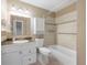 Bright bathroom showcasing a vanity with ample storage, toilet, and bathtub with tiled walls at 2190 S Holly St # 207, Denver, CO 80222