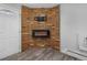 Corner fireplace with a modern electric insert, brick facade, and wall-mounted TV hookup at 2190 S Holly St # 207, Denver, CO 80222