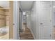 Hallway featuring wood-look floors leads to the bathroom with tile surround, and a bright bedroom at 2190 S Holly St # 207, Denver, CO 80222