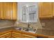 Close-up of the kitchen sink featuring bright light from the window and decorative backsplash at 2190 S Holly St # 207, Denver, CO 80222