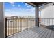 Covered balcony overlooking neighborhood street with black metal railing and gray wooden decking at 6794 Merseyside Ln, Castle Pines, CO 80108