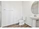 Bathroom with a sleek sink and faucet, a low-flow toilet, and wood-look floors at 6794 Merseyside Ln, Castle Pines, CO 80108