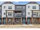 Modern townhomes feature a gray and white exterior with a small fenced yard at 6794 Merseyside Ln, Castle Pines, CO 80108