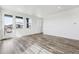 Bright living room with beautiful gray wood floors, large windows, and a door to the outdoor balcony at 6794 Merseyside Ln, Castle Pines, CO 80108