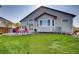 Back of the house with expansive lawn, patio seating, and lush landscaping at 9451 Desert Willow Trl, Highlands Ranch, CO 80129