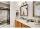 Inviting bathroom featuring wood cabinets, granite countertops, and a glass-enclosed shower at 9451 Desert Willow Trl, Highlands Ranch, CO 80129