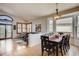 Bright dining area with large windows, a view into the living area, and a sleek black dining set at 9451 Desert Willow Trl, Highlands Ranch, CO 80129
