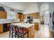 Bright kitchen with wooden cabinets, stainless appliances, a central island, and seamless view of the living area at 9451 Desert Willow Trl, Highlands Ranch, CO 80129