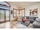 Cozy living area with comfortable seating, plantation shutters, and a door to the patio at 9451 Desert Willow Trl, Highlands Ranch, CO 80129