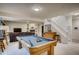 Spacious rec room with billiards table, wet bar, and staircase leading to upper level at 9451 Desert Willow Trl, Highlands Ranch, CO 80129