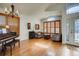 Bright living room with wood floors, plantation shutters, and grand piano by the entry at 9451 Desert Willow Trl, Highlands Ranch, CO 80129