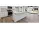 Bright, modern kitchen with stainless steel appliances, large island, and sliding glass doors at 9672 Cathay St, Commerce City, CO 80022
