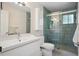 Modern bathroom featuring sleek fixtures, vanity, and a stylish shower with a glass door at 6705 E Jewell Ave, Denver, CO 80224