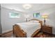 Cozy bedroom with hardwood floors, a wood bed frame, two lamps and a lot of natural light at 6705 E Jewell Ave, Denver, CO 80224