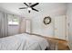 Bright bedroom featuring a ceiling fan, closet, and full-length mirror at 6705 E Jewell Ave, Denver, CO 80224