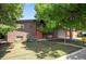 Attractive brick home with a well-manicured lawn and mature trees at 6705 E Jewell Ave, Denver, CO 80224