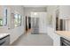 Bright kitchen featuring modern appliances, white cabinetry and a large window for natural light at 6705 E Jewell Ave, Denver, CO 80224