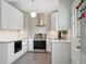 Modern kitchen with sleek white cabinets, stainless steel appliances, and stylish pendant lighting at 6705 E Jewell Ave, Denver, CO 80224