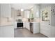 Bright and modern kitchen with white cabinets, stainless steel appliances, and tile floors at 6705 E Jewell Ave, Denver, CO 80224