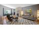 Inviting living room featuring a stylish gray sofa, sleek chairs, stone fireplace, and a chevron patterned rug at 6705 E Jewell Ave, Denver, CO 80224