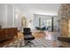 Open-concept living room with vaulted ceilings, fireplace, modern furniture, and large windows at 6705 E Jewell Ave, Denver, CO 80224