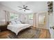 Cozy main bedroom with hardwood floors, a ceiling fan, and large windows overlooking the landscape at 6705 E Jewell Ave, Denver, CO 80224