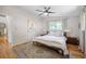Bright main bedroom with hardwood floors, a ceiling fan, a bed, and large windows at 6705 E Jewell Ave, Denver, CO 80224