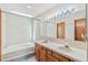 Bright bathroom featuring a soaking tub, dual sinks, and a skylight at 1350 S Idalia St # G, Aurora, CO 80017