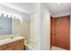 Bright bathroom featuring a tub with beige tiling and wood vanity with ample lighting at 1350 S Idalia St # G, Aurora, CO 80017