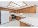Bright eat-in kitchen featuring white appliances, natural wood cabinets, and a skylight at 1350 S Idalia St # G, Aurora, CO 80017