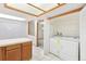 Well-lit laundry area with white appliances, natural wood cabinets, and access to the kitchen at 1350 S Idalia St # G, Aurora, CO 80017