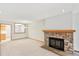 Bright living room features neutral carpet, a stone fireplace, and a view of the kitchen at 1350 S Idalia St # G, Aurora, CO 80017