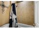 Bathroom with a shower/tub combo and tile surround at 12551 Tamarac St, Thornton, CO 80602