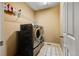 Functional laundry room with washer, dryer, and storage shelves at 12551 Tamarac St, Thornton, CO 80602